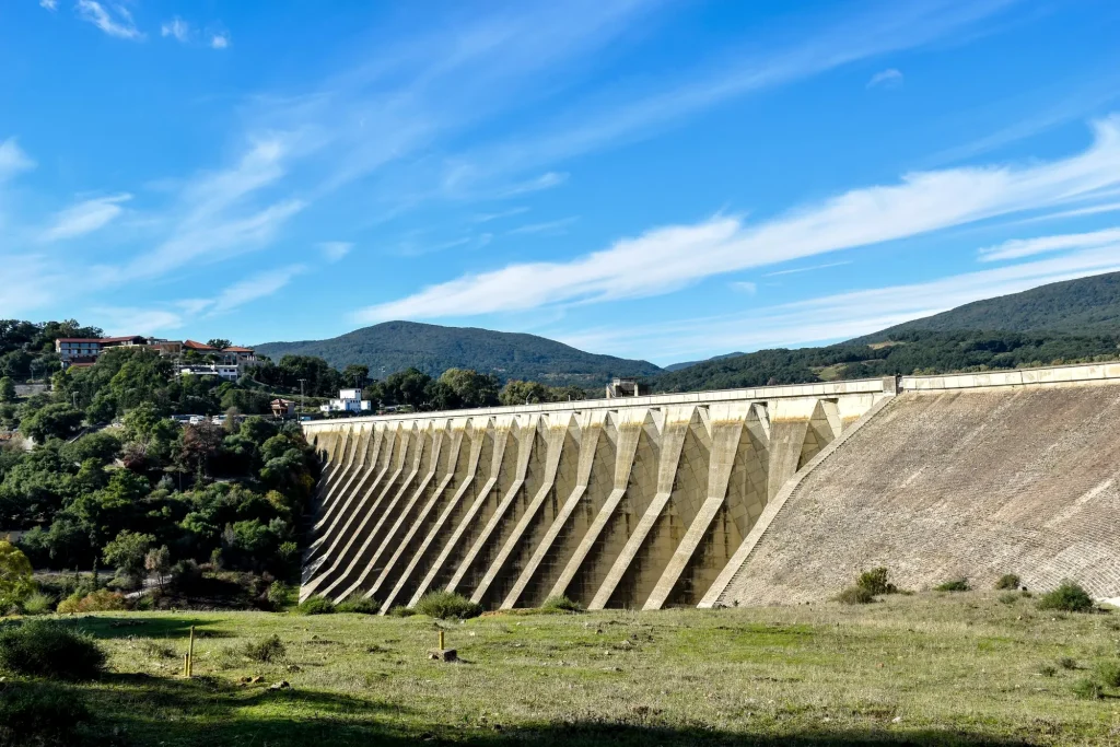 Barragem de concreto em vale, com vegetação no entorno