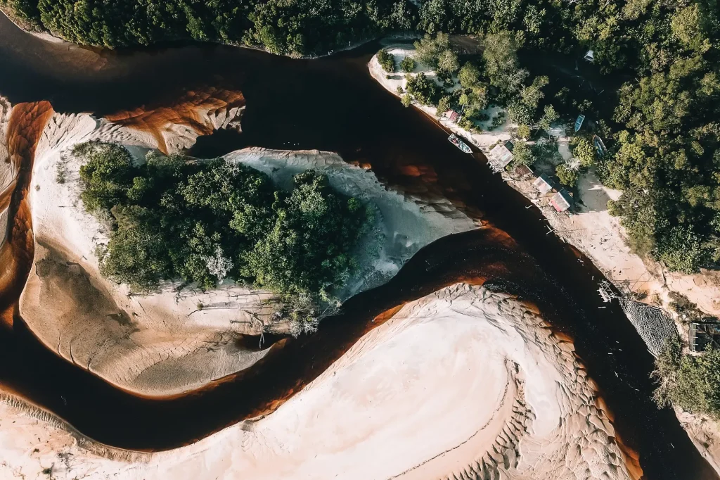 Meandro de rio com bancos de areia e mata, visto de cima