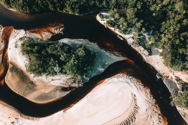 Meandro de rio com bancos de areia e mata, visto de cima