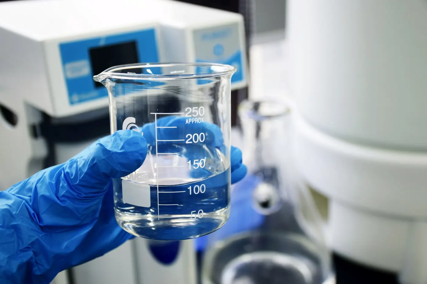 Amostra de água em béquer sendo analisada em laboratório